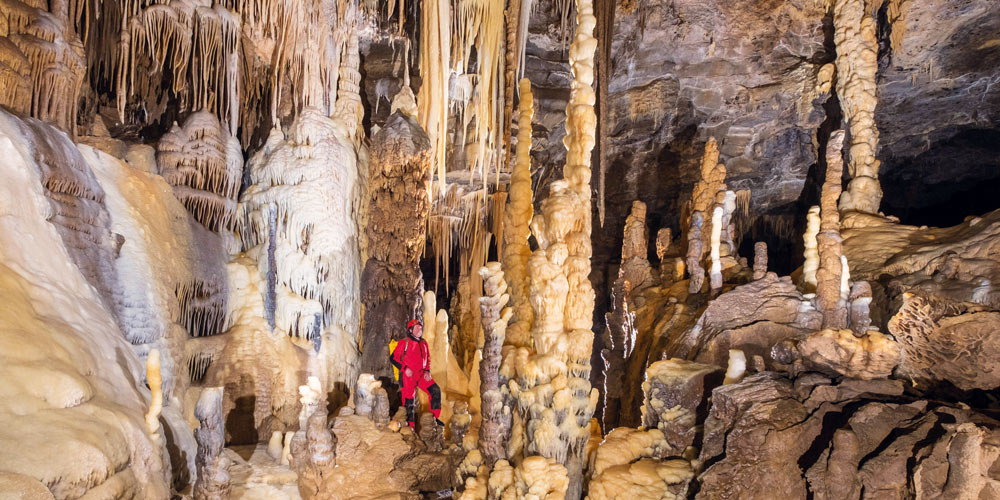 Innenansicht einer Höhle mit einem Mann in rotem Anzug