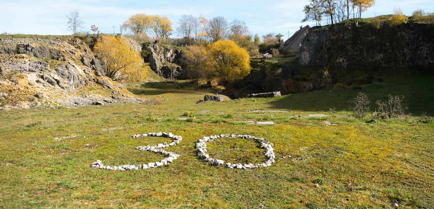 Eine aus Steinen gelegte Zahl Dreißig im Steinbruch beim Naturschutzzentrum Schopflocher Alb